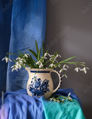 Obraz na płótnie An Elegant Floral Arrangement Placed in a Ceramic Pitcher Surrounded by Beautiful Textiles w salonie