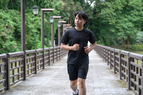 Obraz na płótnie Young Asian male sportsman doing exercise in green park w salonie