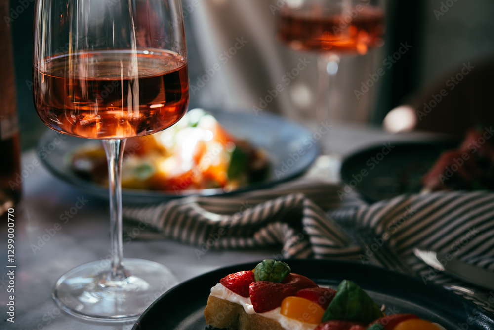A table served for a dinner with prosciutto salad and rose wine in a bar or restaurant.