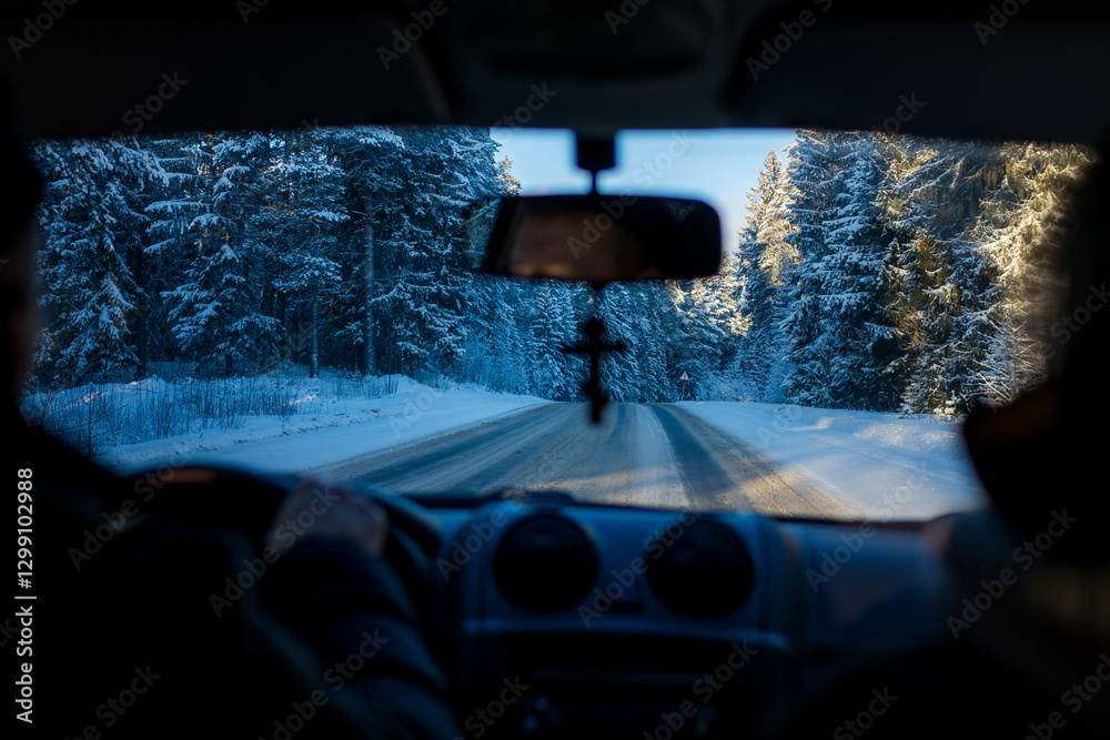 A view from inside a car through the windshield of a snowy Russian highway.