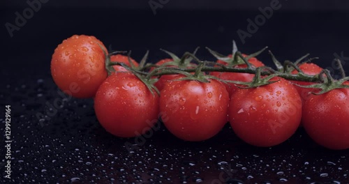 Fresh cherry tomatoes spinning on wet black background. Eating healthy raw organic food, vitamins, vegetables concept. 4k