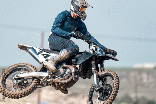 Motocross rider performing a jump during a race on a dirt track