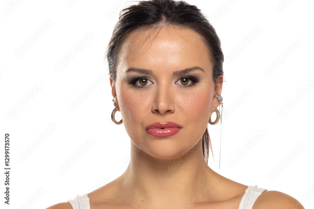 Fototapeta premium Headshot portrait of woman in 30s with makeup on a white studio background.