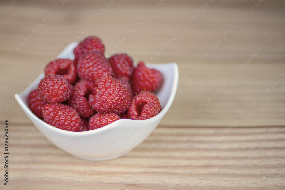 Fresh raspberries in a white plate close-up Fresh raspberries in a white plate close-up