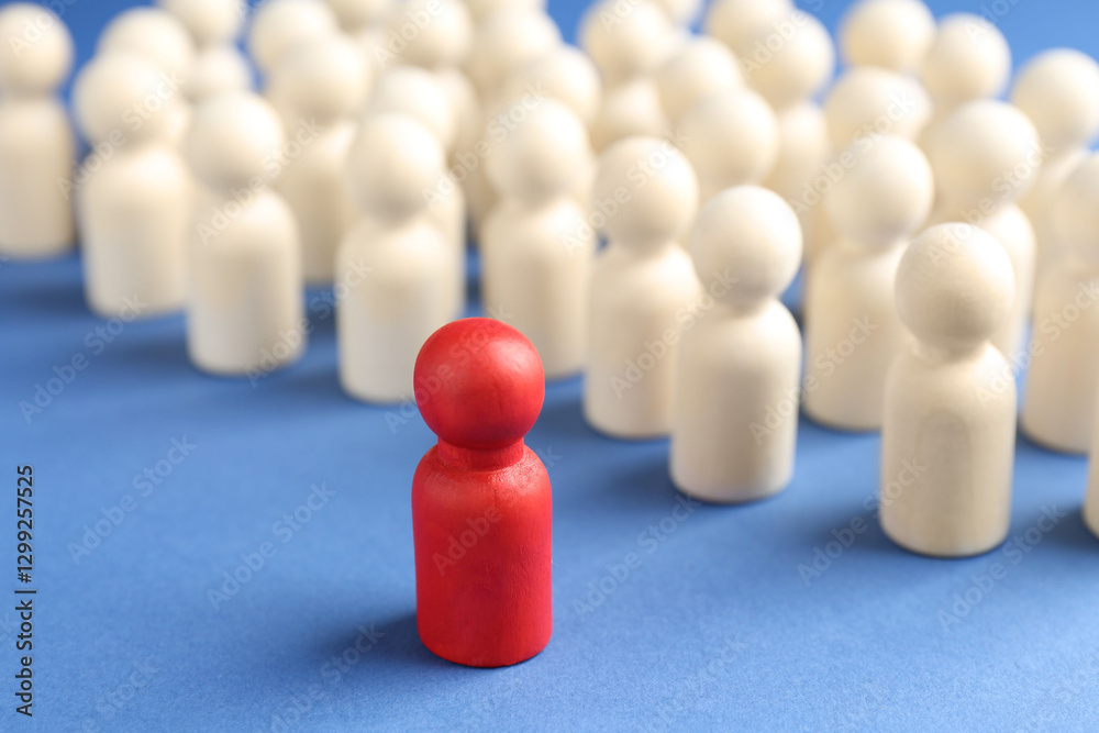Competition concept. Red human figure ahead of other ones on blue background, closeup Competition concept. Red human figure ahead of other ones on blue background, closeup
