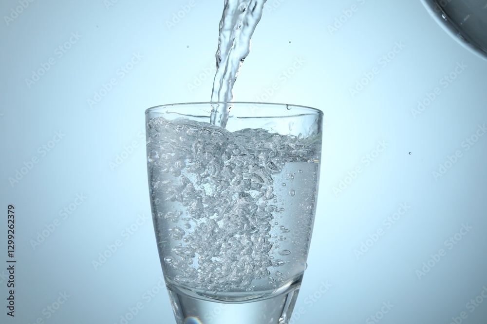 Pouring refreshing soda water into glass on light background, closeup Pouring refreshing soda water into glass on light background, closeup