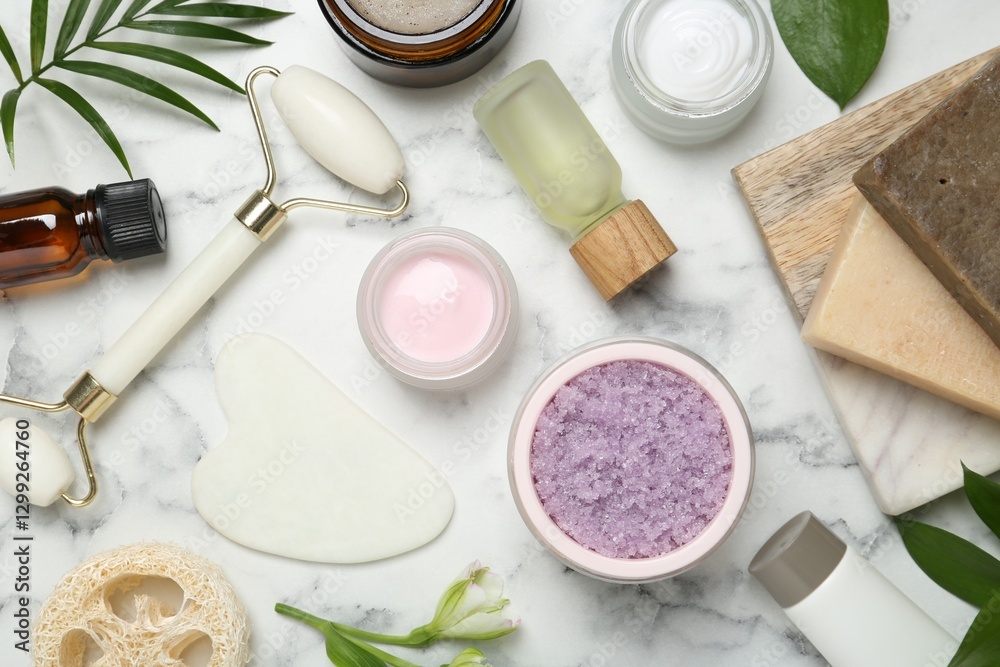 Flat lay composition with different body care products and flowers on white marble table Flat lay composition with different body care products and flowers on white marble table