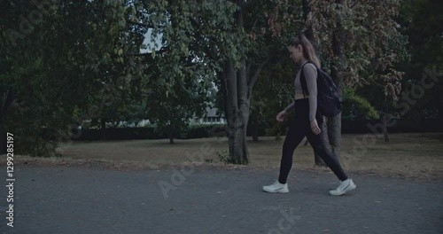 Wallpaper Mural A young woman takes a peaceful evening stroll through a serene park, enjoying the fresh air and tranquility. Torontodigital.ca