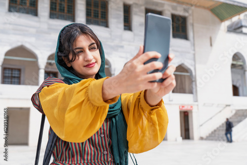 Young Muslim woman taking selfie while traveling