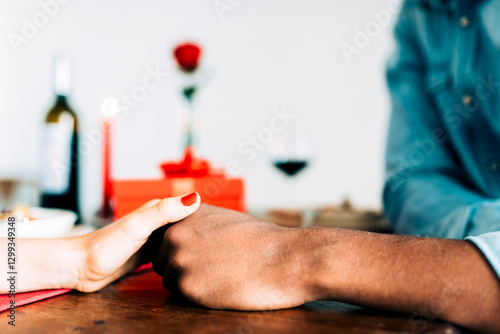 Romantic dinner scene with couple holding hands intimately photo