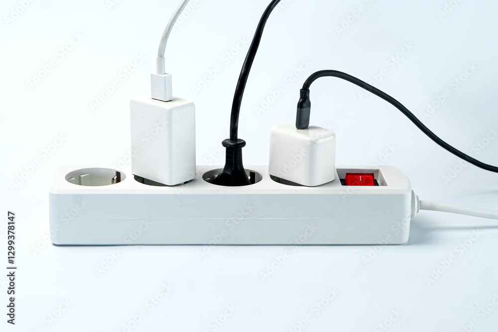A close-up of a white power strip with multiple plugs connected, showcasing a clean and organized setup against a light background, ideal for home or office use. A close-up of a white power strip with multiple plugs connected, showcasing a clean and organized setup against a light background, ideal for home or office use.