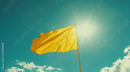 Bright yellow flag waving against sunny blue sky with fluffy clouds