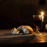Holy communion bread and red wine in dim candlelight, symbolizing the Last Supper, faith, and Christian religious traditions