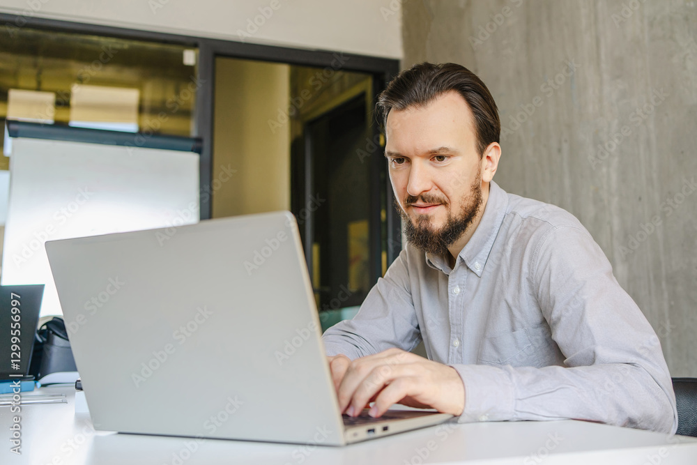 Man Productively Working on Laptop at Office Desk Man Productively Working on Laptop at Office Desk