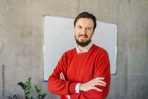 Man in red sweater standing near office whiteboard photo