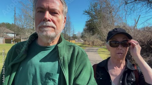elderly couple walking on a trail in a park close view