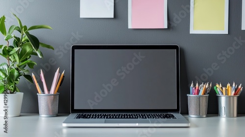 Inspiring home office scene with laptop surrounded by pencils post it notes and green plant productivity in modern workspace