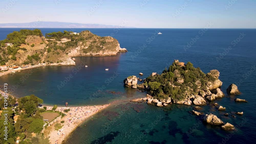 Enjoy a captivating view of the lush coastline and clear waters of Taormina Sicily Italy, where sunbathers relax on the sandy beach and boats gently glide across the horizon under a bright blue sky. Enjoy a captivating view of the lush coastline and clear waters of Taormina Sicily Italy, where sunbathers relax on the sandy beach and boats gently glide across the horizon under a bright blue sky.