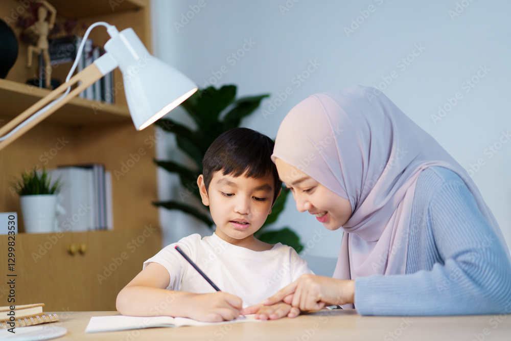 Asian muslim woman is teaching and reviewing homework with her son. Asian muslim woman is teaching and reviewing homework with her son.