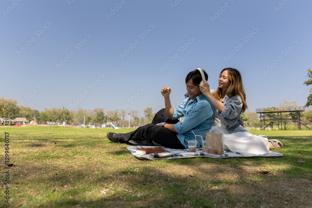 a couple is having a picnic on the lawn in the middle if the day when the weather is nice, the couple is spending time together happily, they enjoys spending time together on Valentine's day a couple is having a picnic on the lawn in the middle if the day when the weather is nice, the couple is spending time together happily, they enjoys spending time together on Valentine's day
