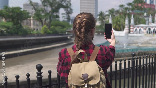 Female tourist with backpack enjoying view of Jamek Mosque photo