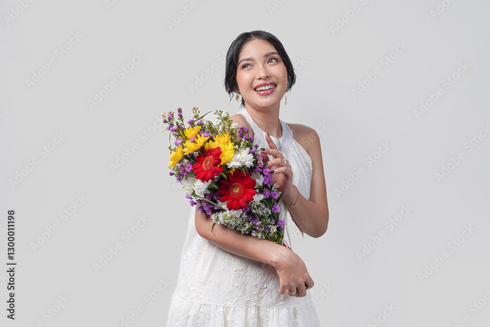 Pregnant Asian woman holding a bouquet of flowers while pointing to the copy space behind her. Pregnant Asian woman holding a bouquet of flowers while pointing to the copy space behind her.