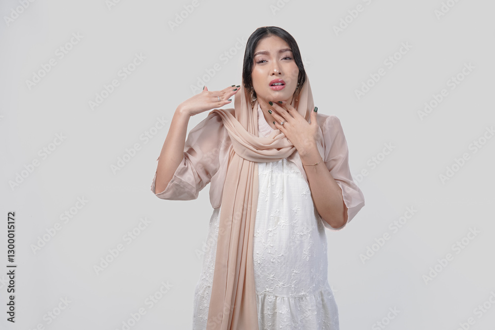 Asian Muslim woman raising hand to fan herself feeling hot due to summer weather while fasting. Asian Muslim woman raising hand to fan herself feeling hot due to summer weather while fasting.