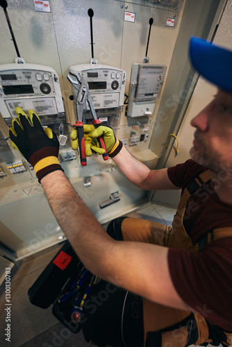 Obraz na płótnie Electrician working on a modern electricity power meter station in a building. w salonie