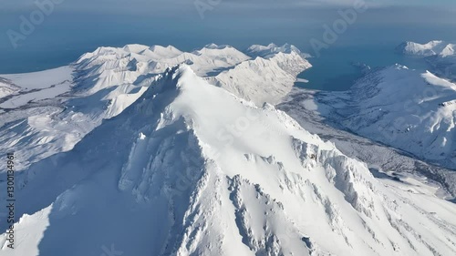 Aerial view of winter snow-covered mountains and ocean view