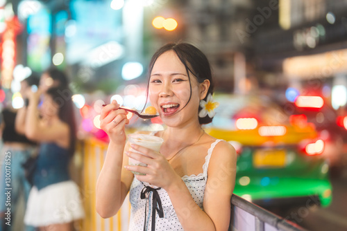 Photography Happy asian tourist woman eating thai tasty dessert at China town asia street fo