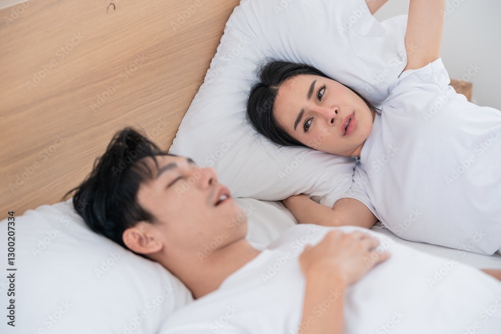 Couple in bed experiencing discomfort during sleep in a bright room Couple in bed experiencing discomfort during sleep in a bright room