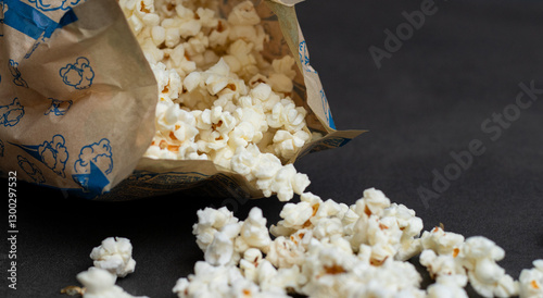 Fresh popcorn in bag made in a microwave on grey kitchen table