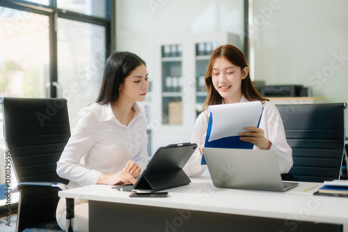 Businesswoman leading team meeting and using tablet and laptop computer with financial