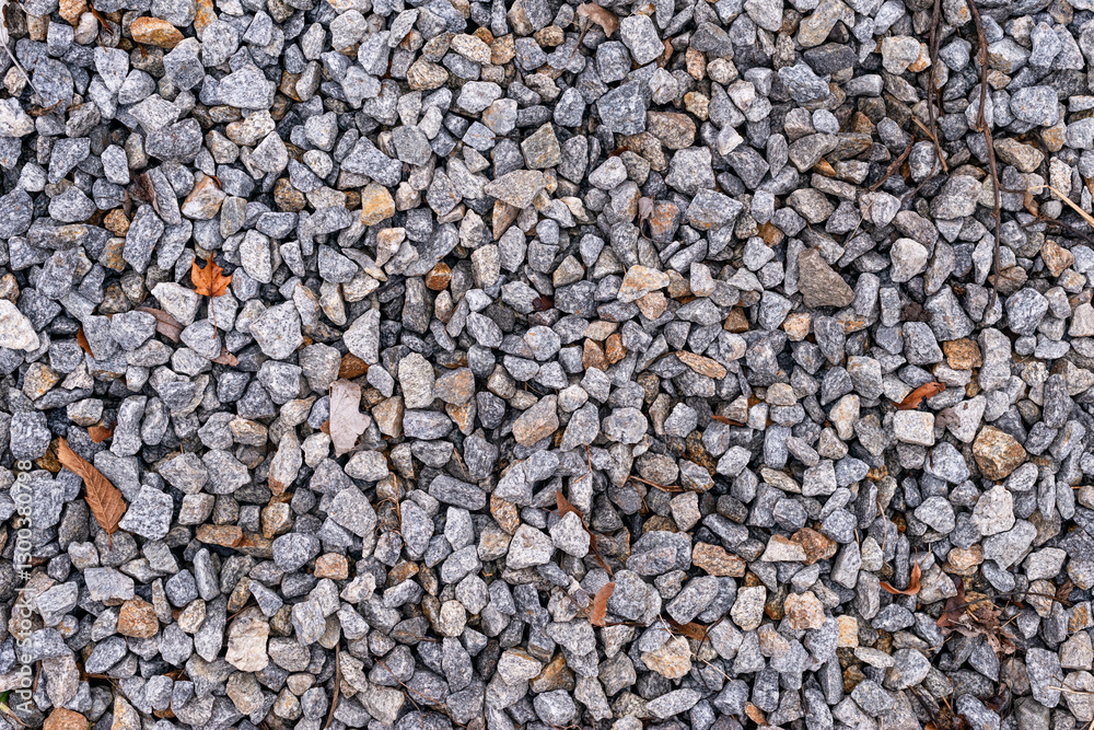 Close-up of a crushed stone texture. Gray stones of various sizes and shapes create a neutral and natural background. Close-up of a crushed stone texture. Gray stones of various sizes and shapes create a neutral and natural background.