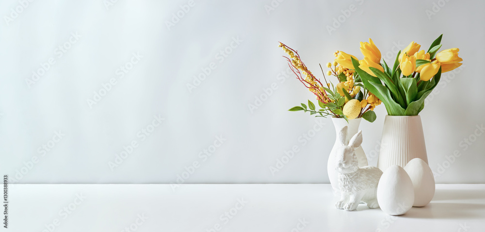 A white vase of yellow tulips and eggs on a white table A white vase of yellow tulips and eggs on a white table