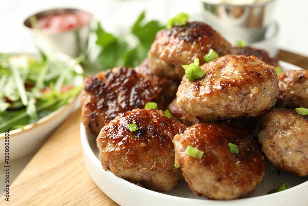 Delicious patties with green onions on table, closeup Delicious patties with green onions on table, closeup
