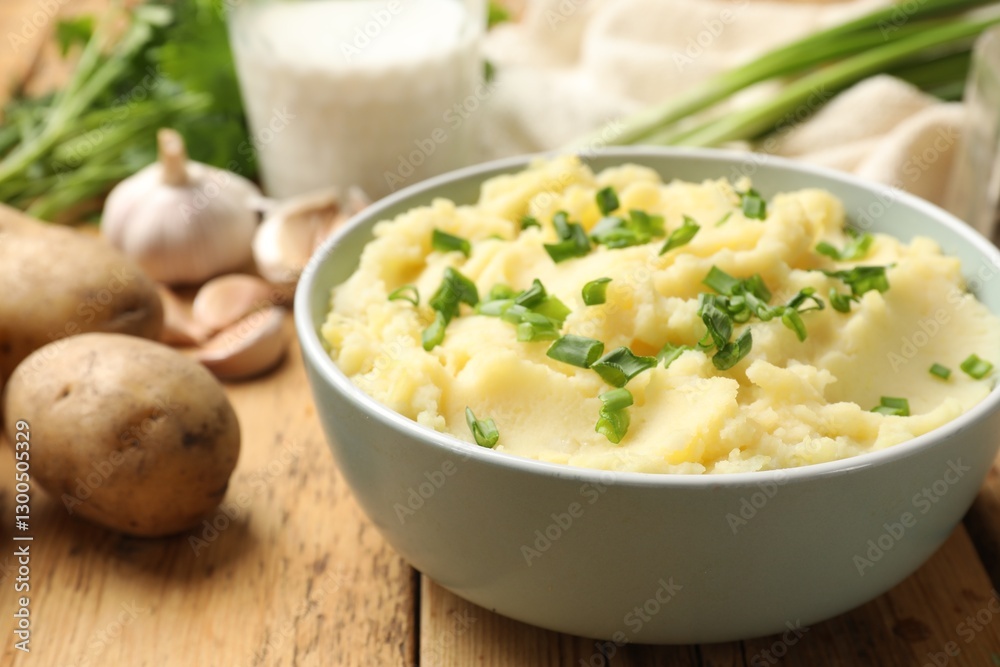 Delicious mashed potato with green onions on wooden table, closeup Delicious mashed potato with green onions on wooden table, closeup