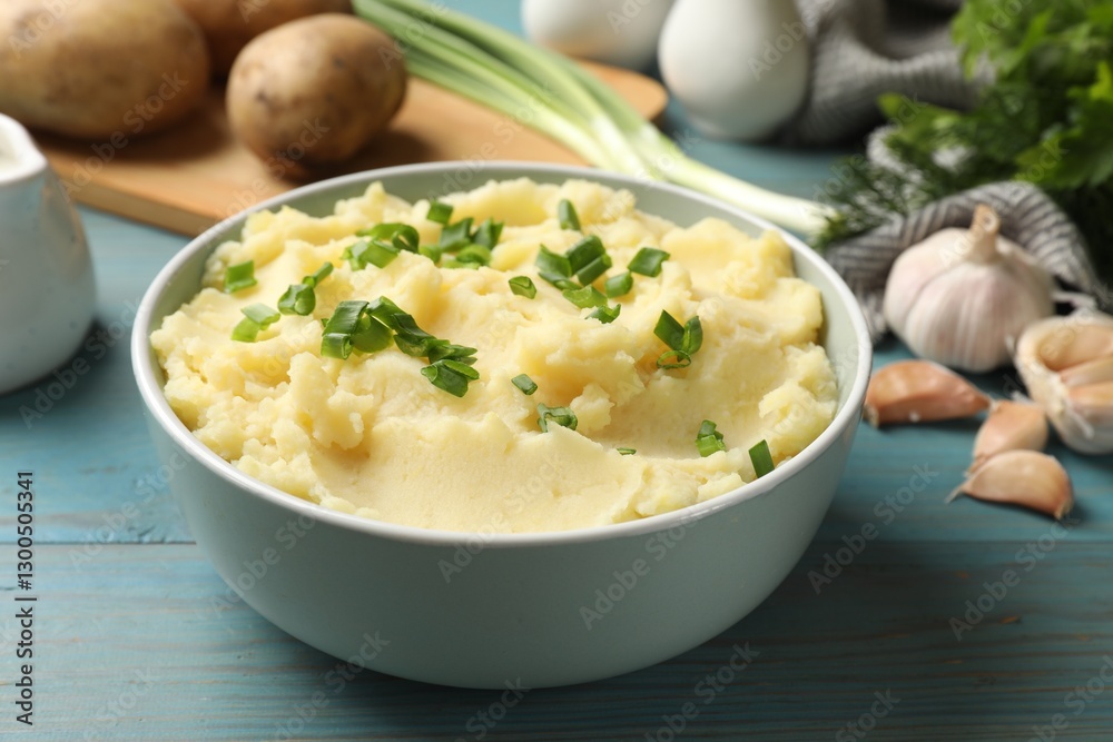 Delicious mashed potato with green onions served on light blue wooden table, closeup Delicious mashed potato with green onions served on light blue wooden table, closeup