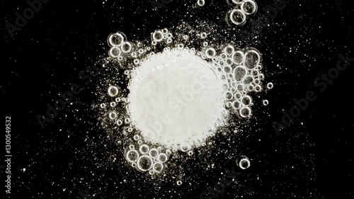 Close-up effervescent tablet vitamin, white pill dissolves with bubbles, round bubbling aspirin in water, slow motion. High quality 4k footage