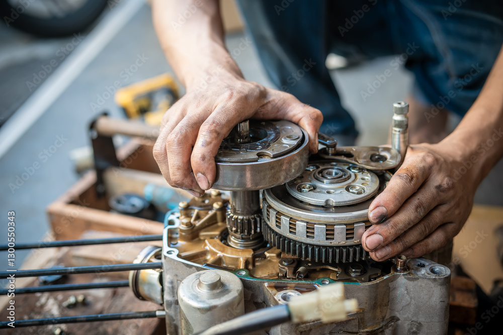 Motorcycle mechanic working on the repair of a motorcycle engine ,working at garage, maintenance, repair motorcycle concept