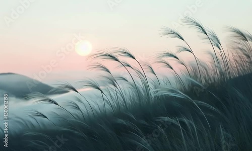 Gentle Grass Silhouettes Against a Soft Sunrise Over Misty Hills in a Tranquil Landscape