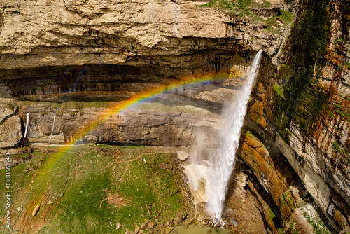 Natural plateau in the settlement of Khunzakh in Dagestan in Russia, a natural picture with a splashing waterfall and a beautiful colored rainbow and a settlement, houses