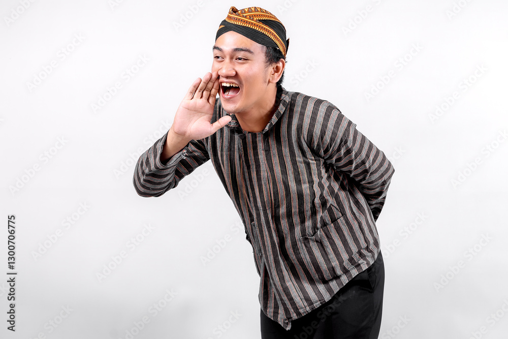 A young man wearing traditional lurik attire smiles widely while gesturing as if calling out, showcasing cultural pride and enthusiasm against a neutral background. A young man wearing traditional lurik attire smiles widely while gesturing as if calling out, showcasing cultural pride and enthusiasm against a neutral background.