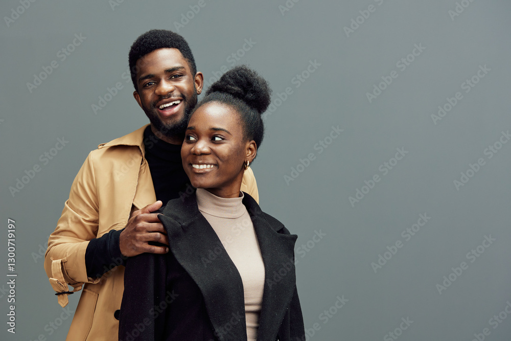 Smiling couple in stylish outfits against a gray background, showcasing modern fashion and joyful emotions, perfect for relationship or lifestyle themes Smiling couple in stylish outfits against a gray background, showcasing modern fashion and joyful emotions, perfect for relationship or lifestyle themes