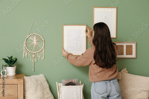 Young woman hanging blank f...