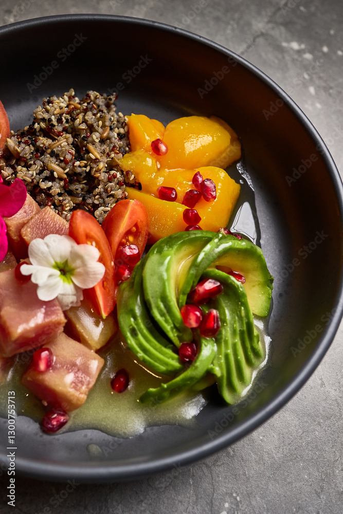 Colorful bowl with quinoa, avocado, tuna, cherry tomatoes, pomegranate seeds, peaches, flower garnish, superfood mix, vibrant presentation, healthy eating concept