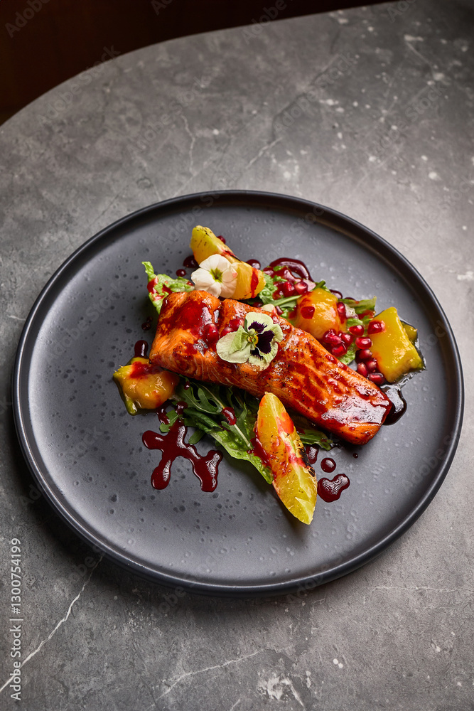 Gourmet Grilled Salmon with Citrus and Pomegranate Garnish on Dark Plate, Elegant Food Presentation Concept