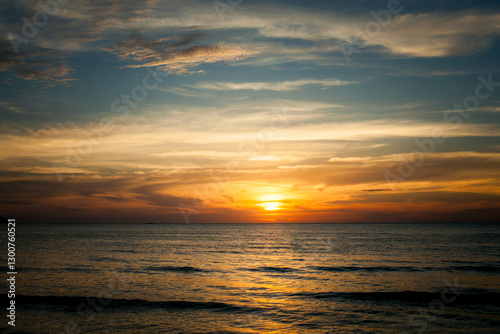 Obraz na płótnie A tropical seaside beach during a stunning sunset, radiating a calm and peaceful atmosphere. w salonie