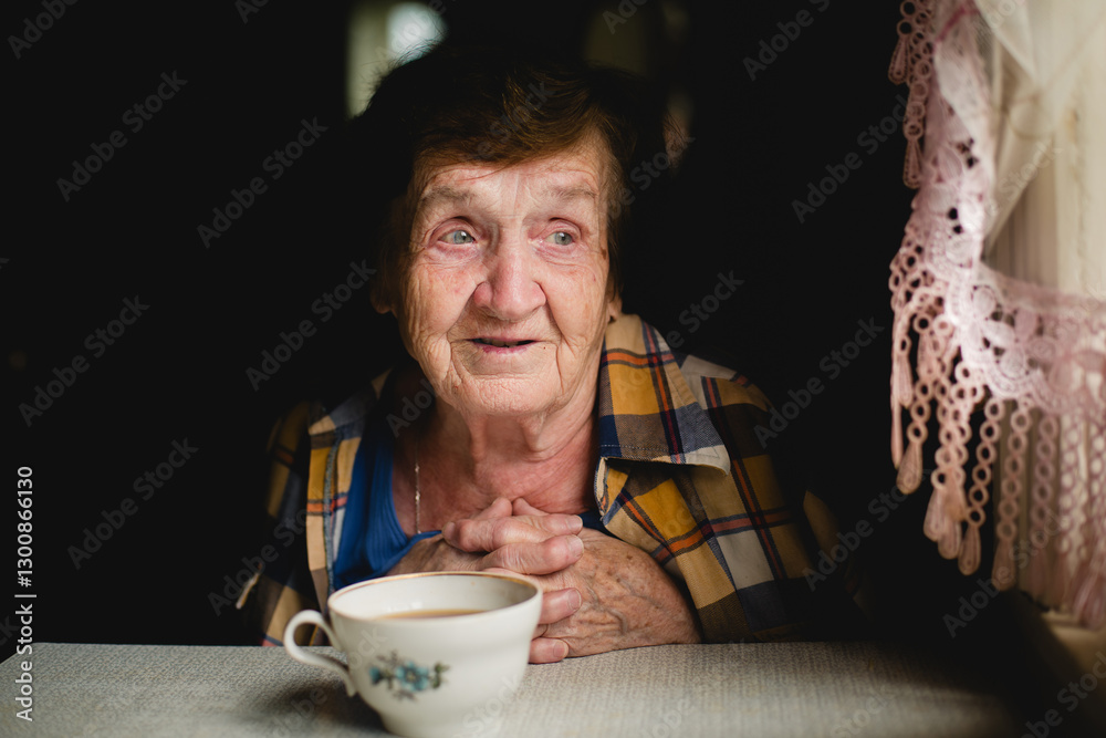 A touching portrait of an elderly woman sitting at a table with a cup of tea, radiating warmth and care.