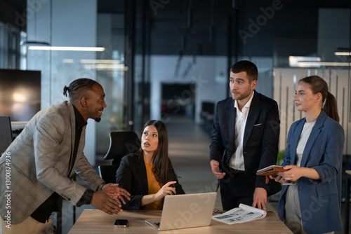 Diverse business team in discussion at a modern office, engaged in a professional meeting. Concept of teamwork, corporate collaboration, and workplace communication